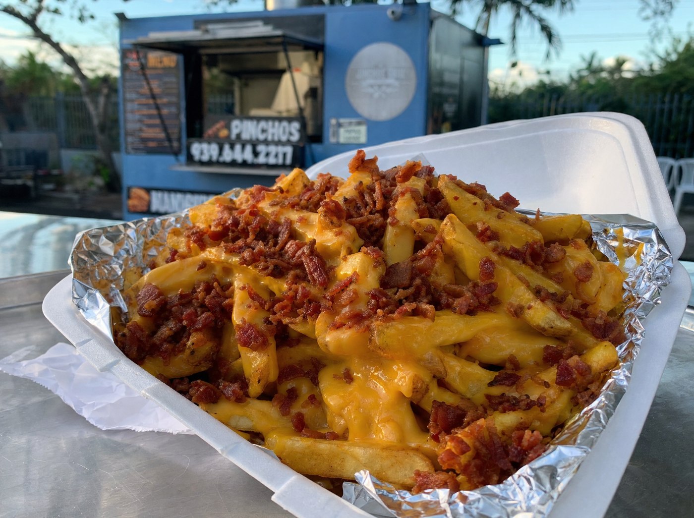 Papas doradas con queso derretido y bacon crujiente